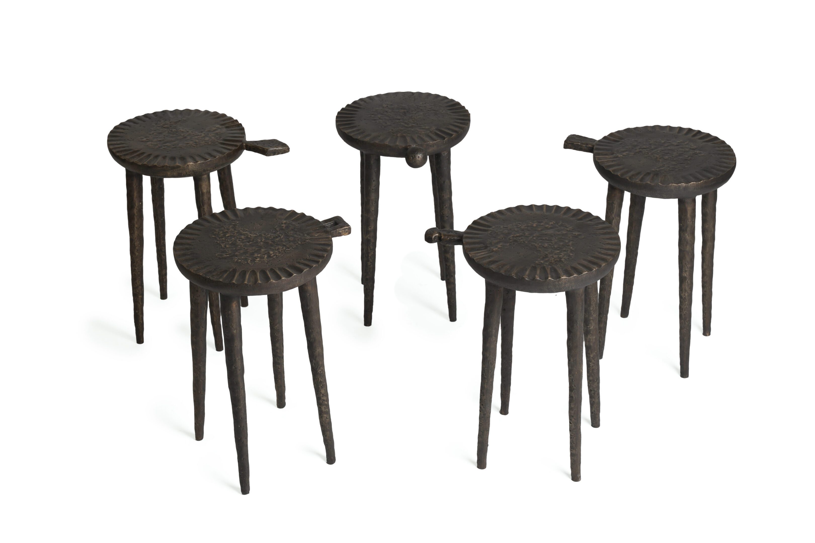 Five carved wooden three-legged stools