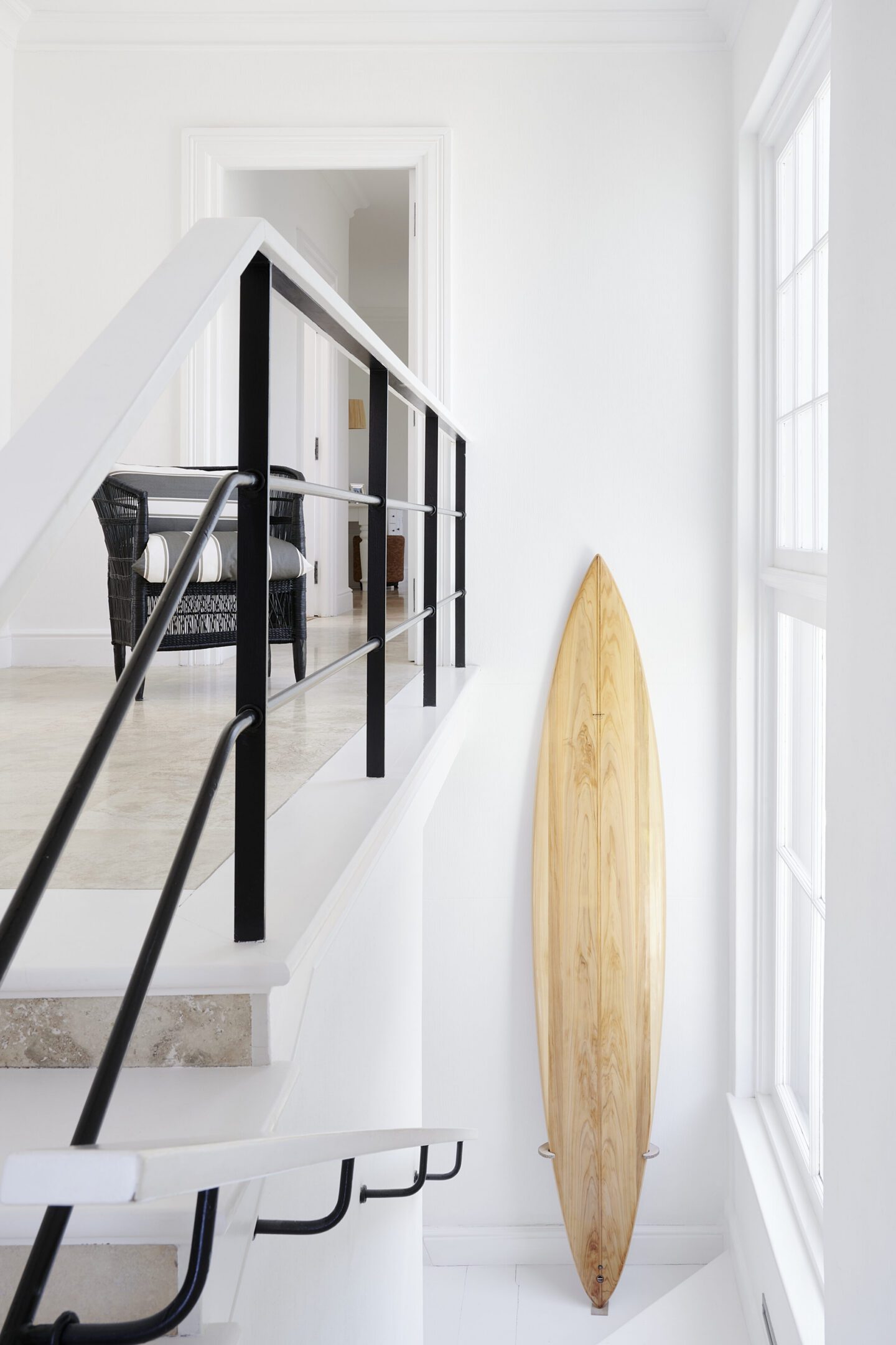White staircase interior with wooden surfboard